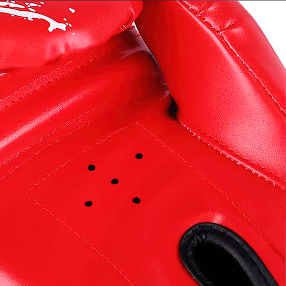 Red boxing training glove with paint splash design, featuring ventilation holes and secure hook-and-loop wrist strap for sparring and fitness.