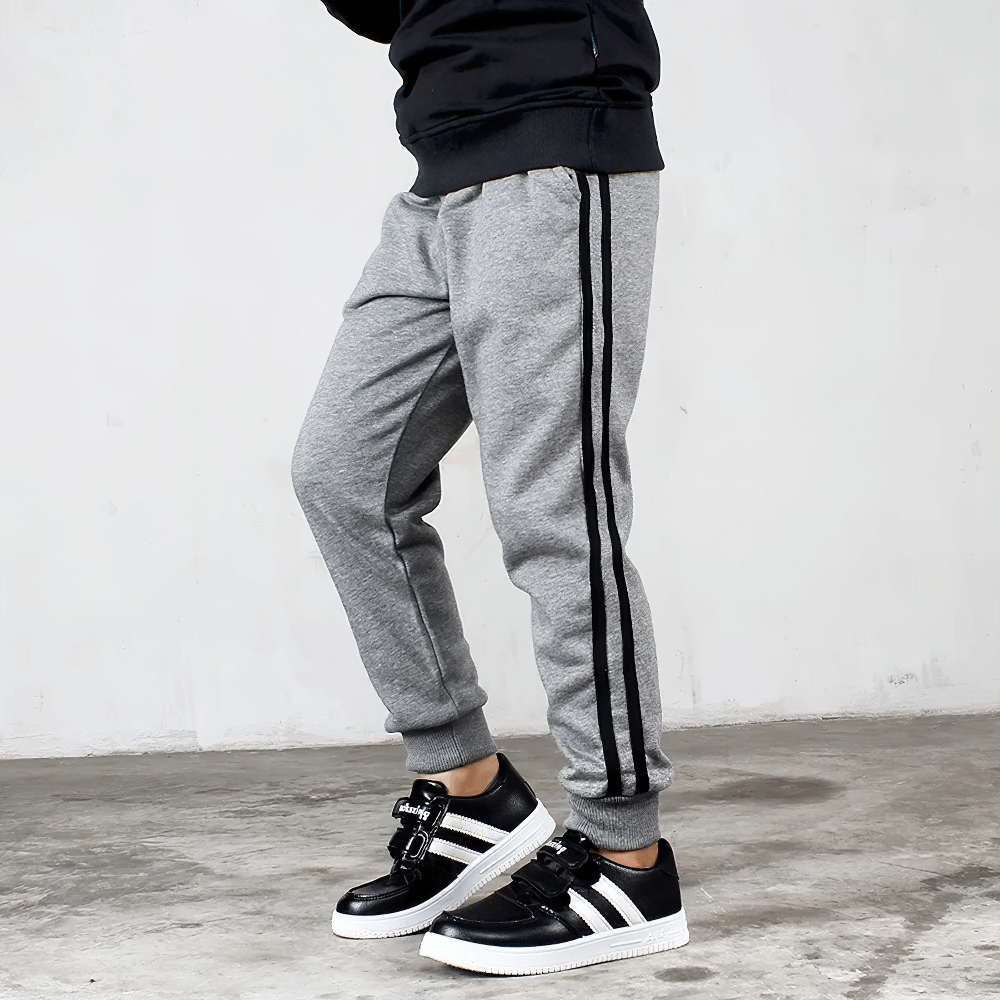 Boy wearing Boys Athletic Jogger Sweatpants with Pockets - SF3611 in grey, showing elastic waistband and stylish stripes.