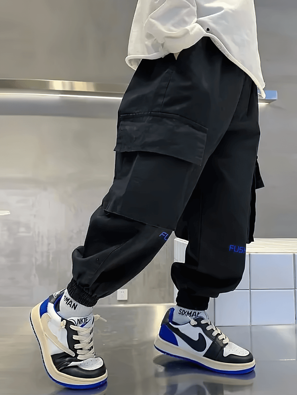 Boy wearing Boys Cargo Jogger Pants with Side Pockets - SF3865, black streetwear style, ankle length with elastic waist and oversized pockets.