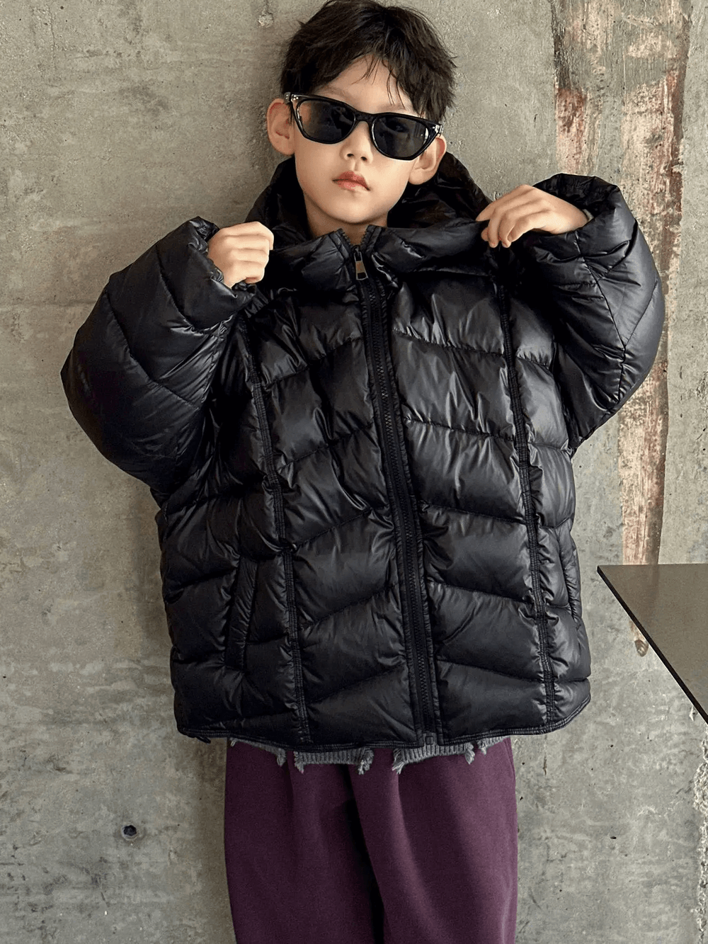 Stylish boy in black Boys Hooded Down Puffer Jacket With Zipper - SF3638, showcasing a trendy winter look against a rustic backdrop.