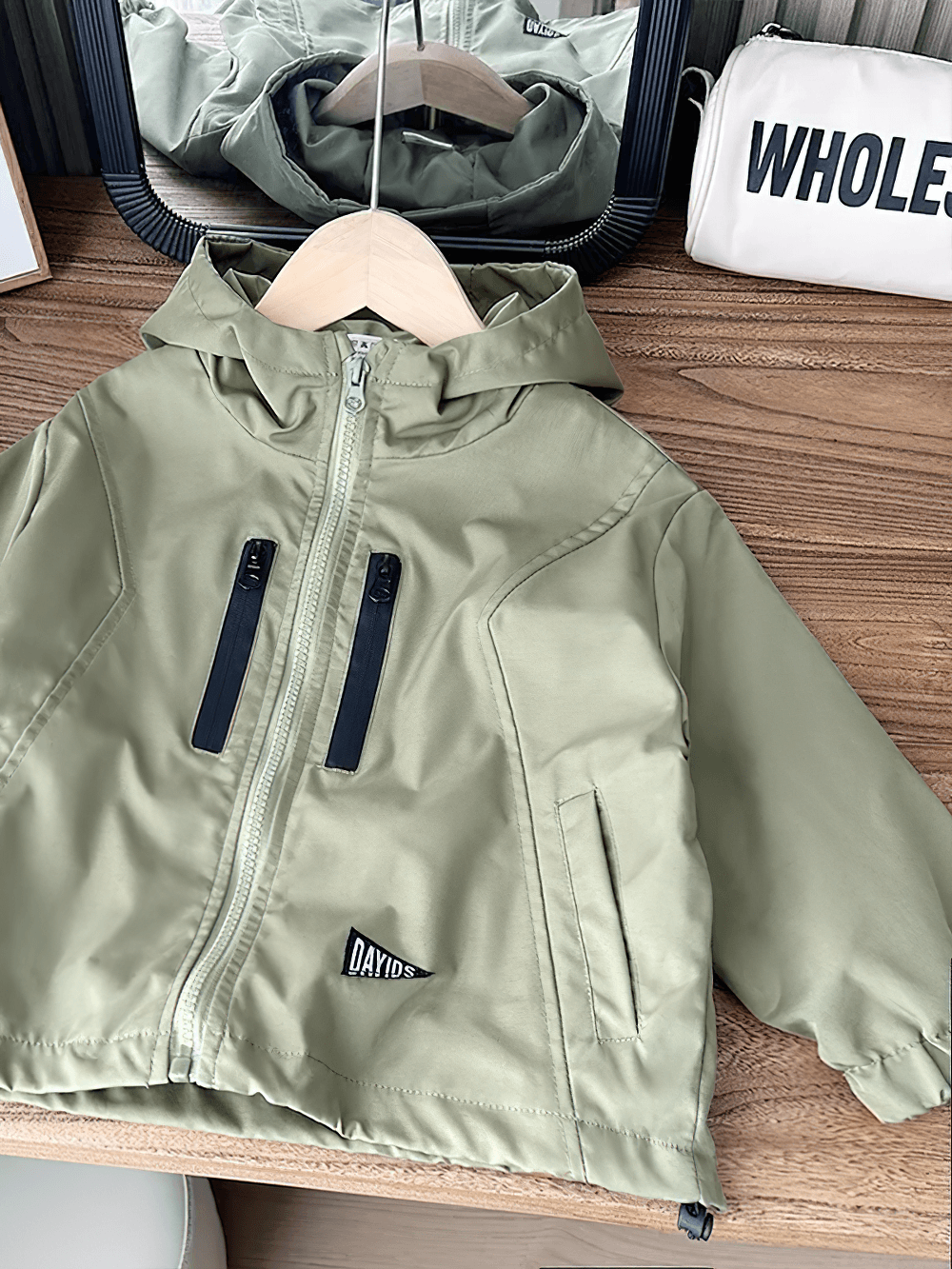 Boys Hooded Zipper Windbreaker Jacket - SF3565 in stylish olive green color, displayed on a wooden hanger in a chic room setting.