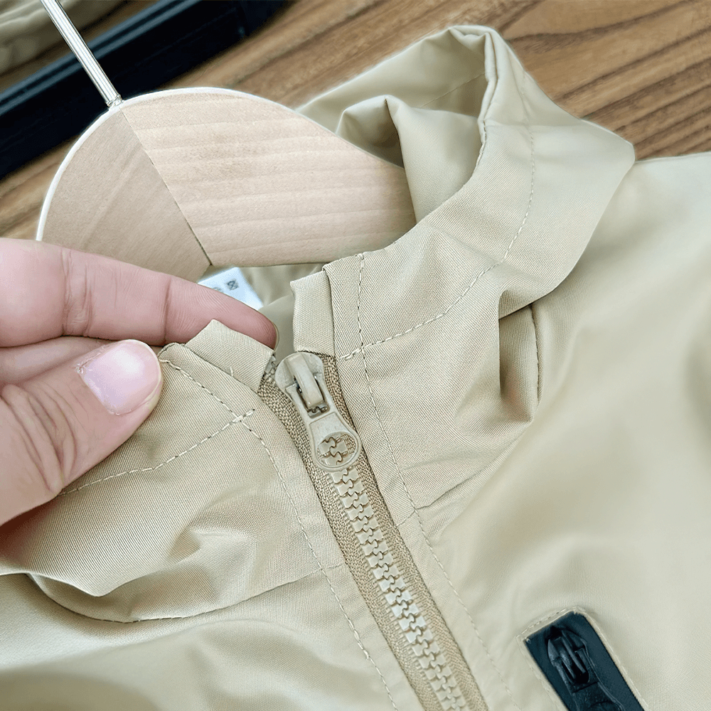 Close-up of Boys Hooded Zipper Windbreaker Jacket - SF3565 showing zipper detail and hood on a wooden hanger.