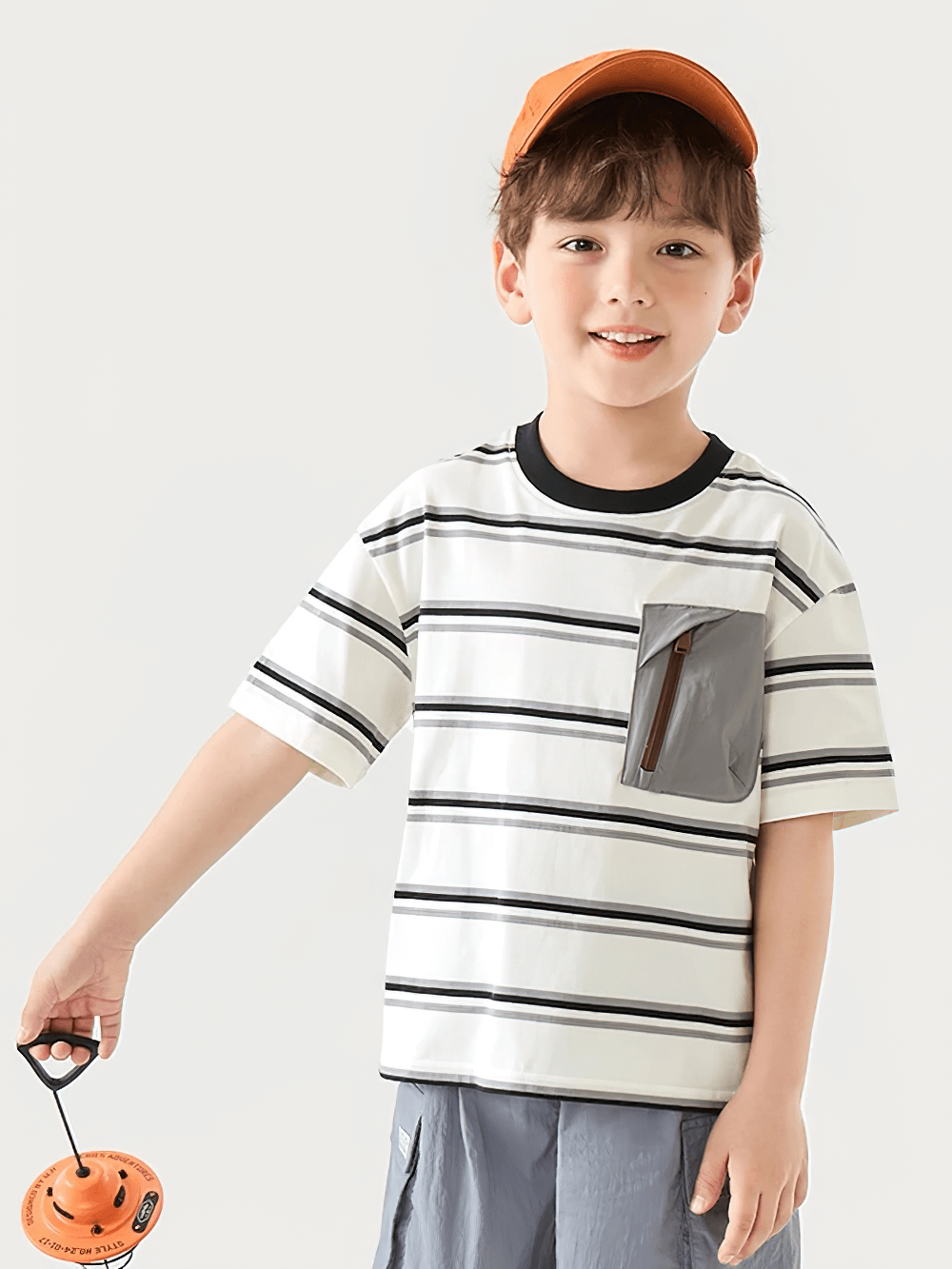 Happy boy wearing Boys Stripe T-Shirt with Zipper Chest Pocket - SF3682, ideal for outdoor adventures, holding a toy.