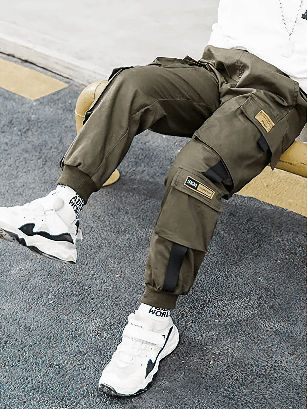 Boy wearing Boys Stylish Sport Cargo Jogger Pants - SF3868 with sneakers, showcasing utility pockets and sporty styling while sitting.