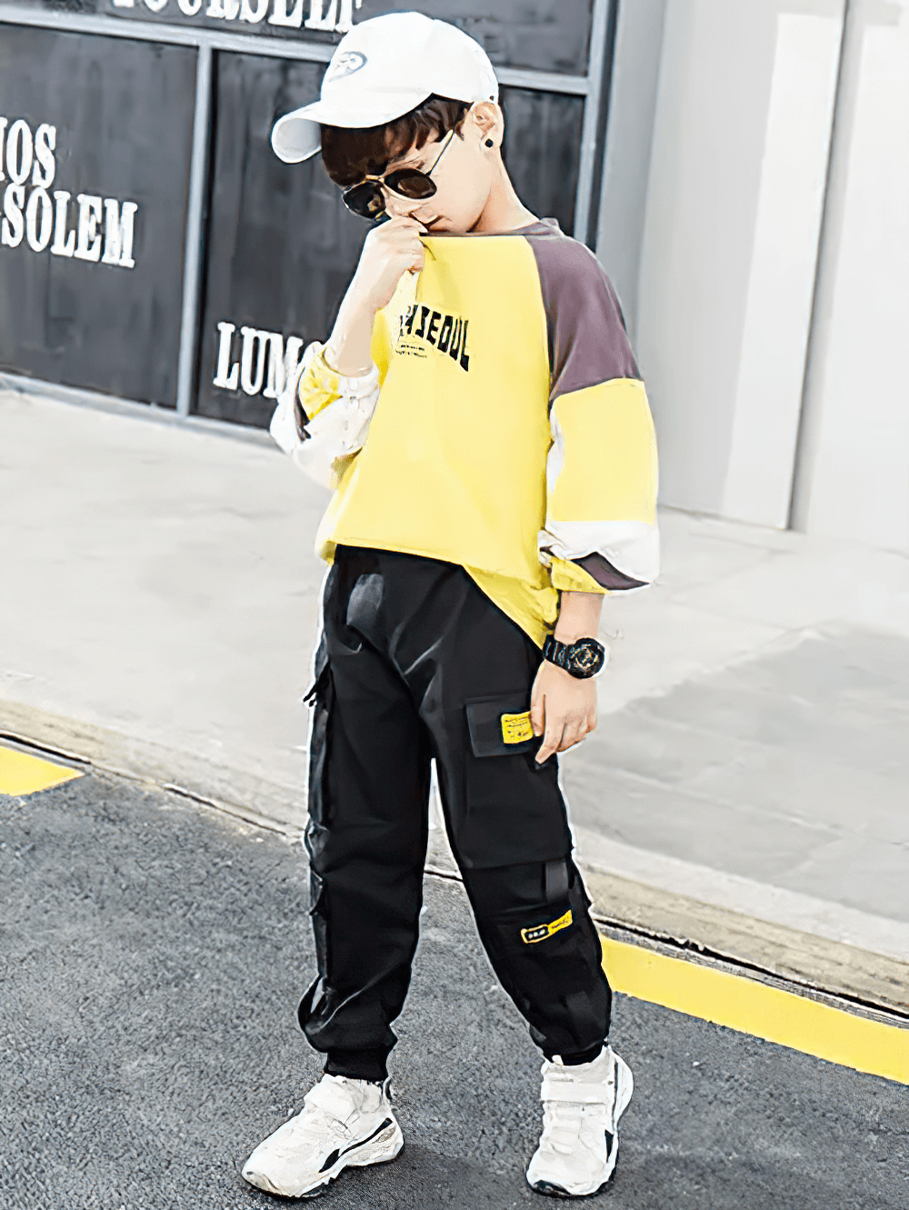 Young boy wearing Boys Stylish Sport Cargo Jogger Pants - SF3868 with sneakers and a cap, showcasing urban street style.