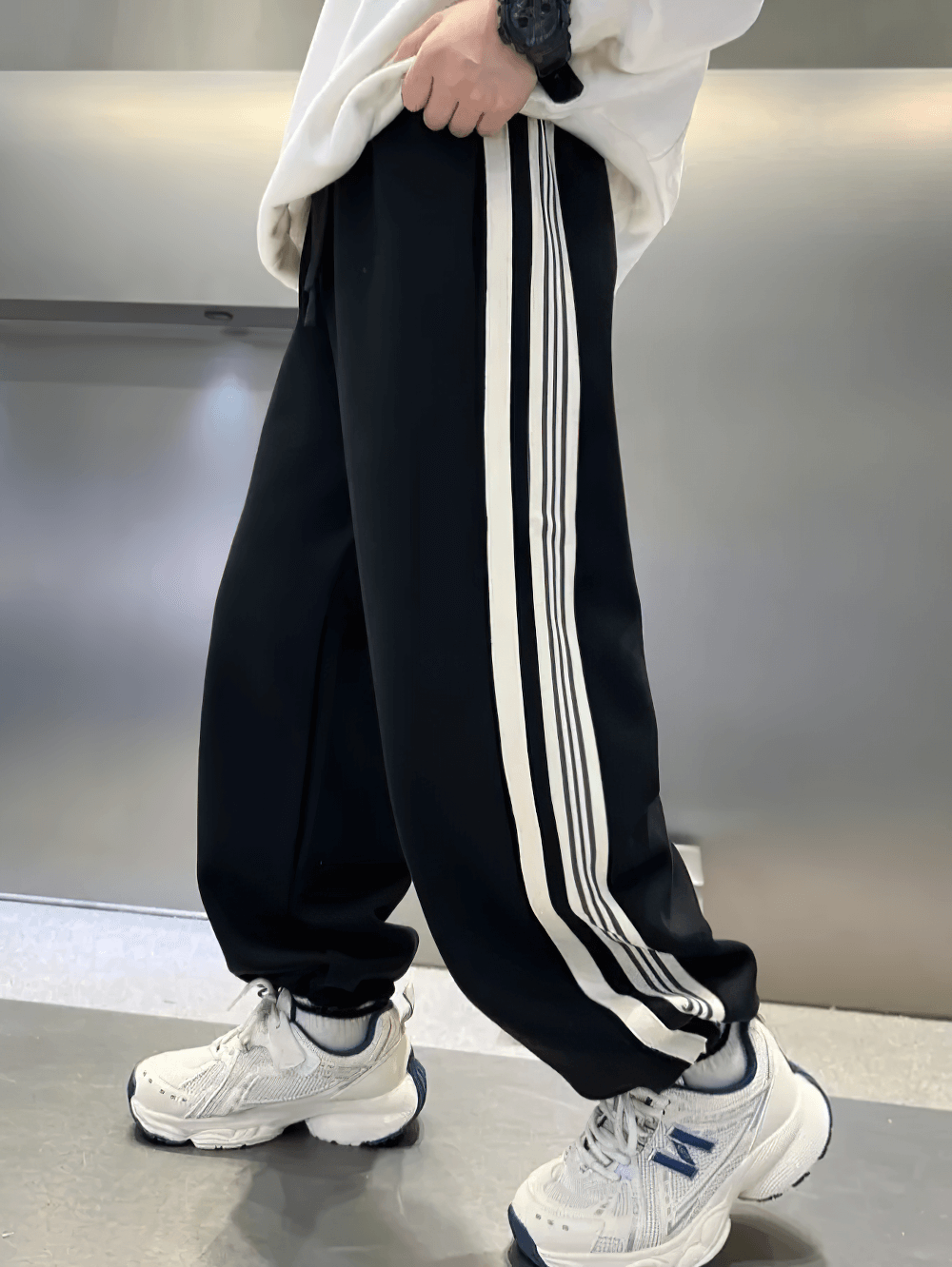 Boy in Boys Trendy Sport Pants with Stripes - SF3705, wide-leg design, wearing white sneakers.