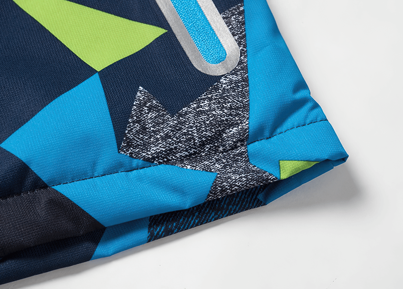 Close-up of geometric print on Boys Waterproof Hooded Outdoor Sport Jacket - SF3600, showing blue, green, and gray pattern. Perfect for kids.