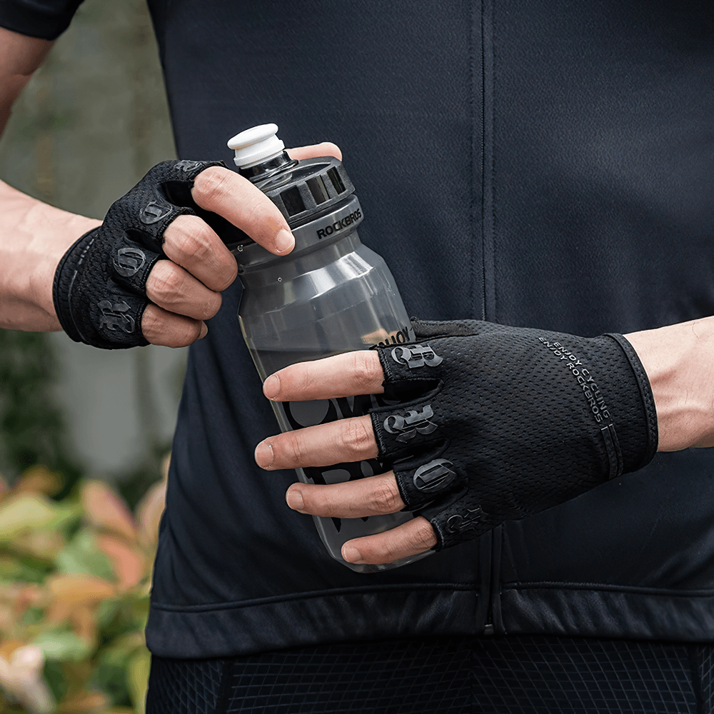 Cyclist wearing breathable half-finger cycling gloves holding water bottle, featuring SBR palm pads for anti-shock and grip.