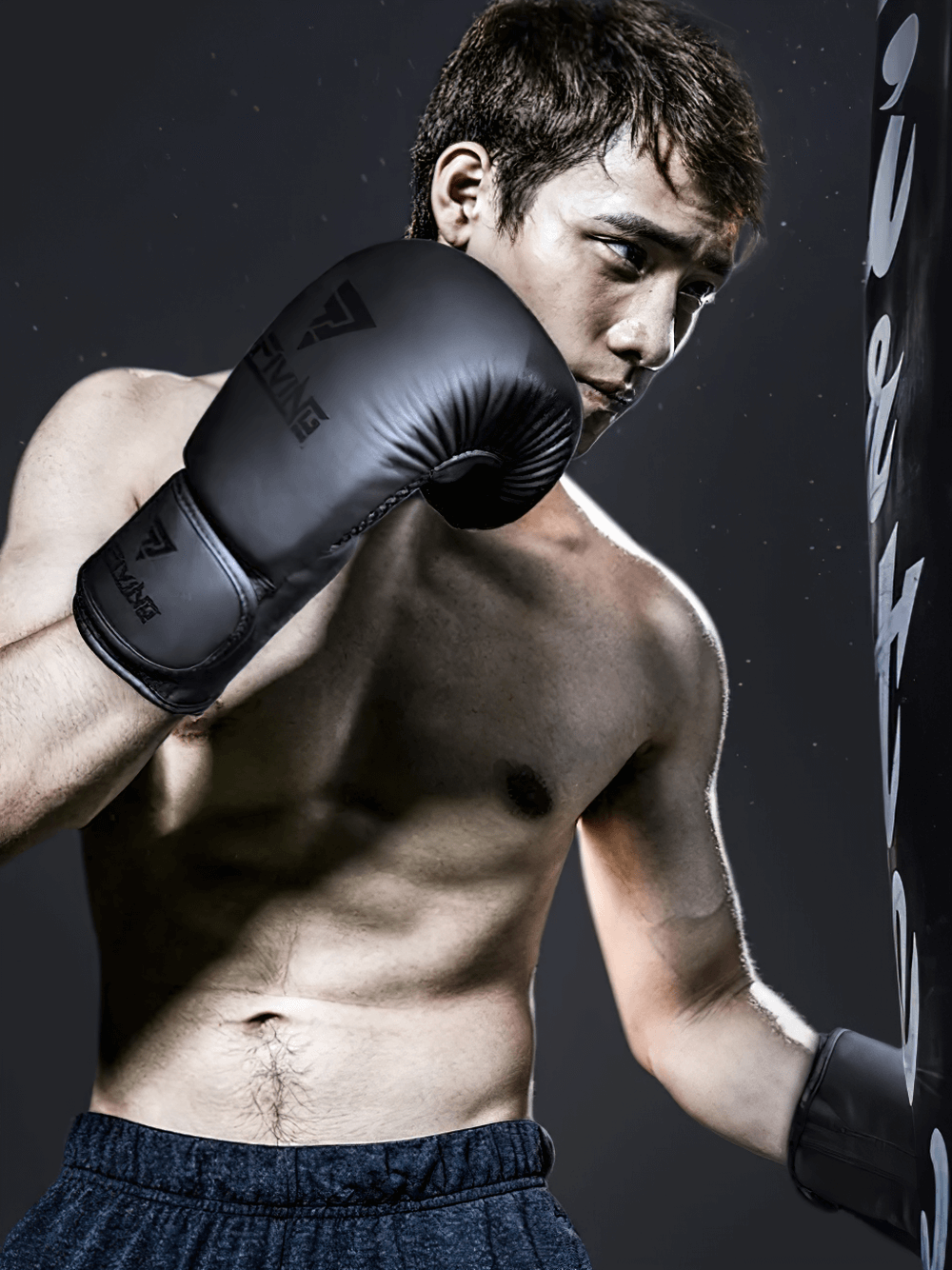 Boxer wearing breathable boxing gloves SF2692 punching a bag, showcasing ergonomic design and wrist support for intense training.