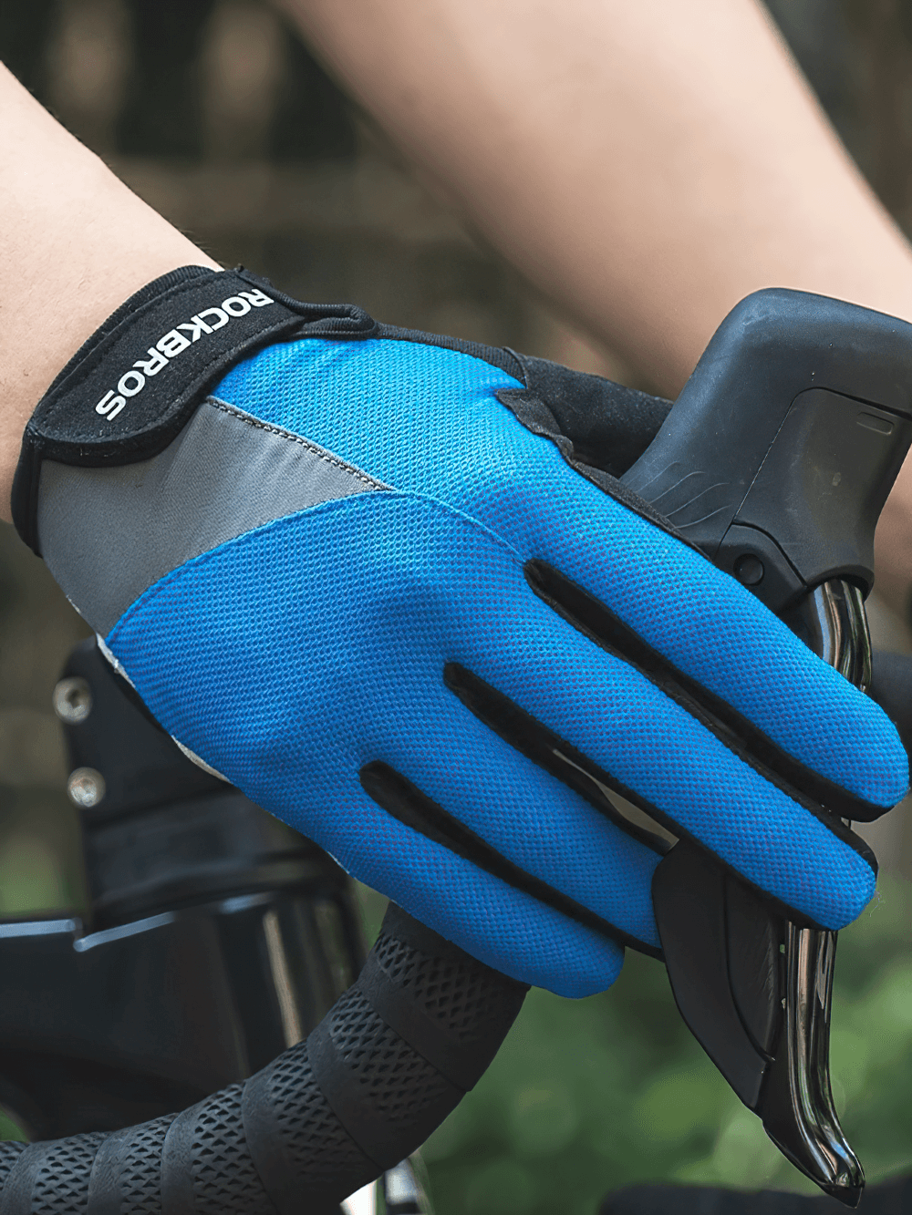 Blue windproof cycling glove with touchscreen fingertips gripping a bicycle handle.