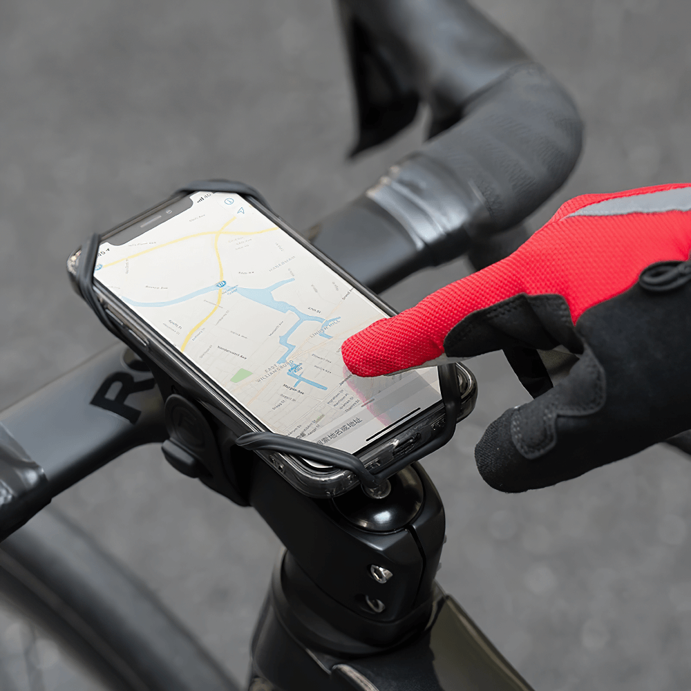 Cyclist using touchscreen phone with red breathable cycling gloves SF2623 featuring SBR padding, on a bike handlebar mount.