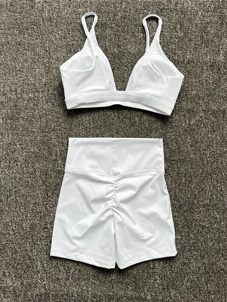 Breathable elastic women's sports bra and shorts set SF1757 in white, perfect for yoga and activewear, laid out on a gray background.