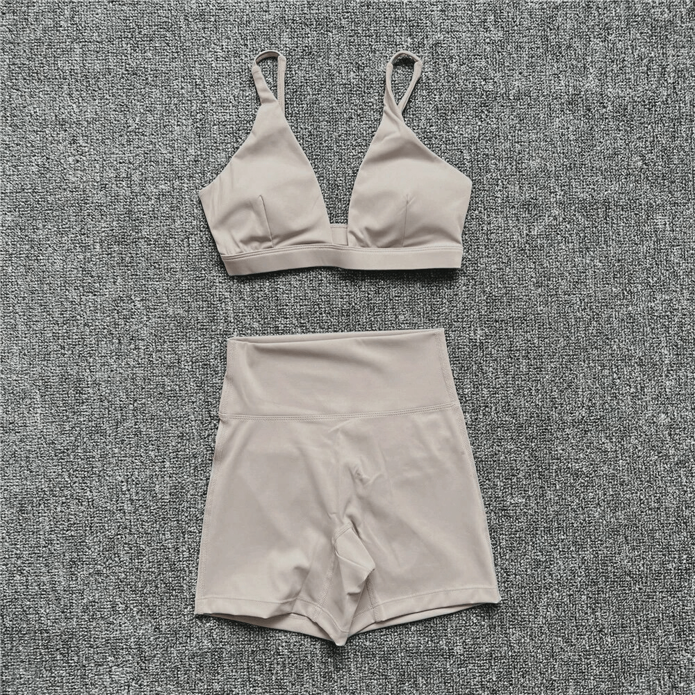Breathable elastic women's suit, including sports bra and shorts, ideal for yoga and exercise, in a stylish solid color.