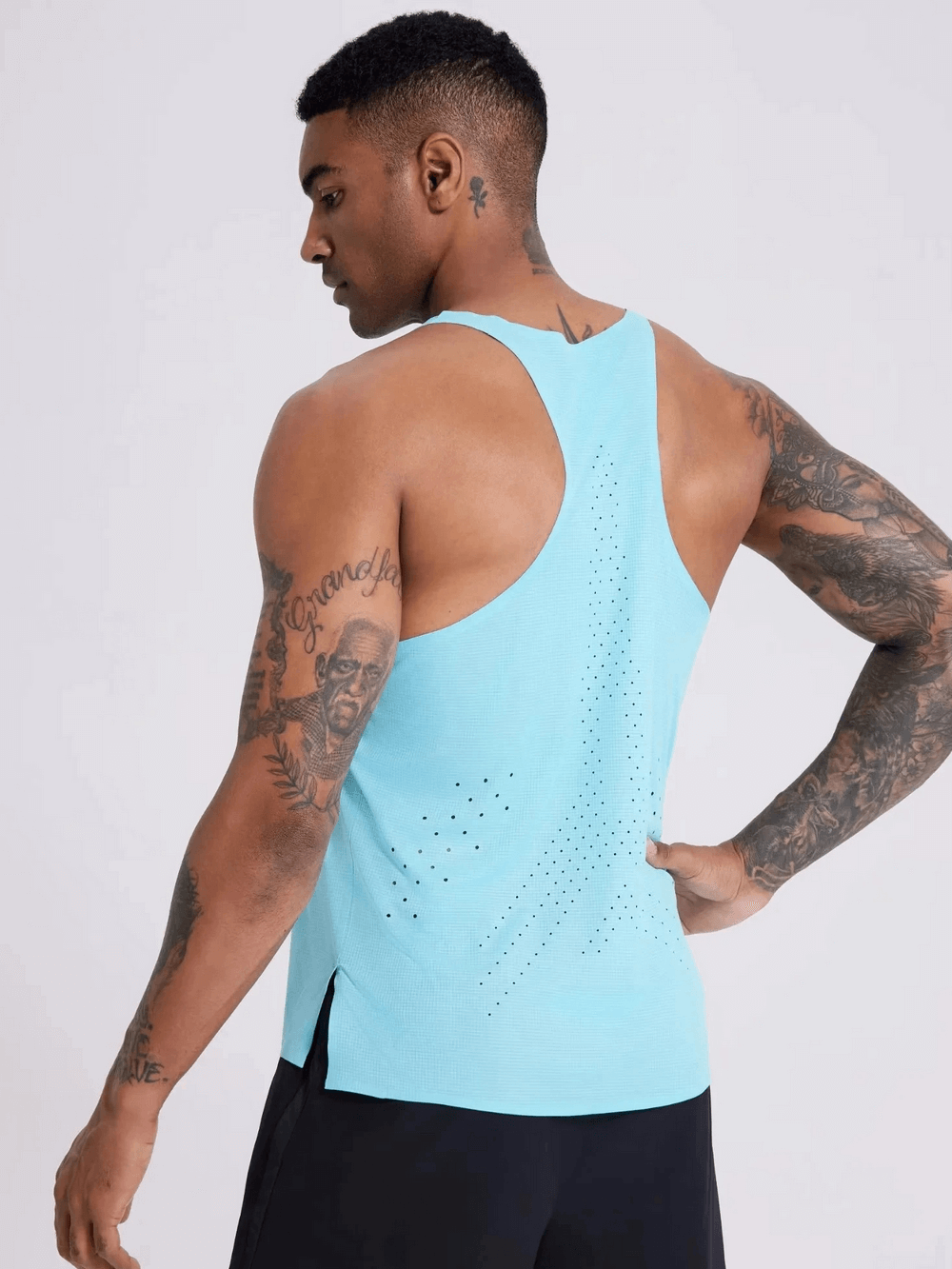Man wearing a breathable men's tank top in vibrant blue with perforated design, showcasing athletic fit from the back.