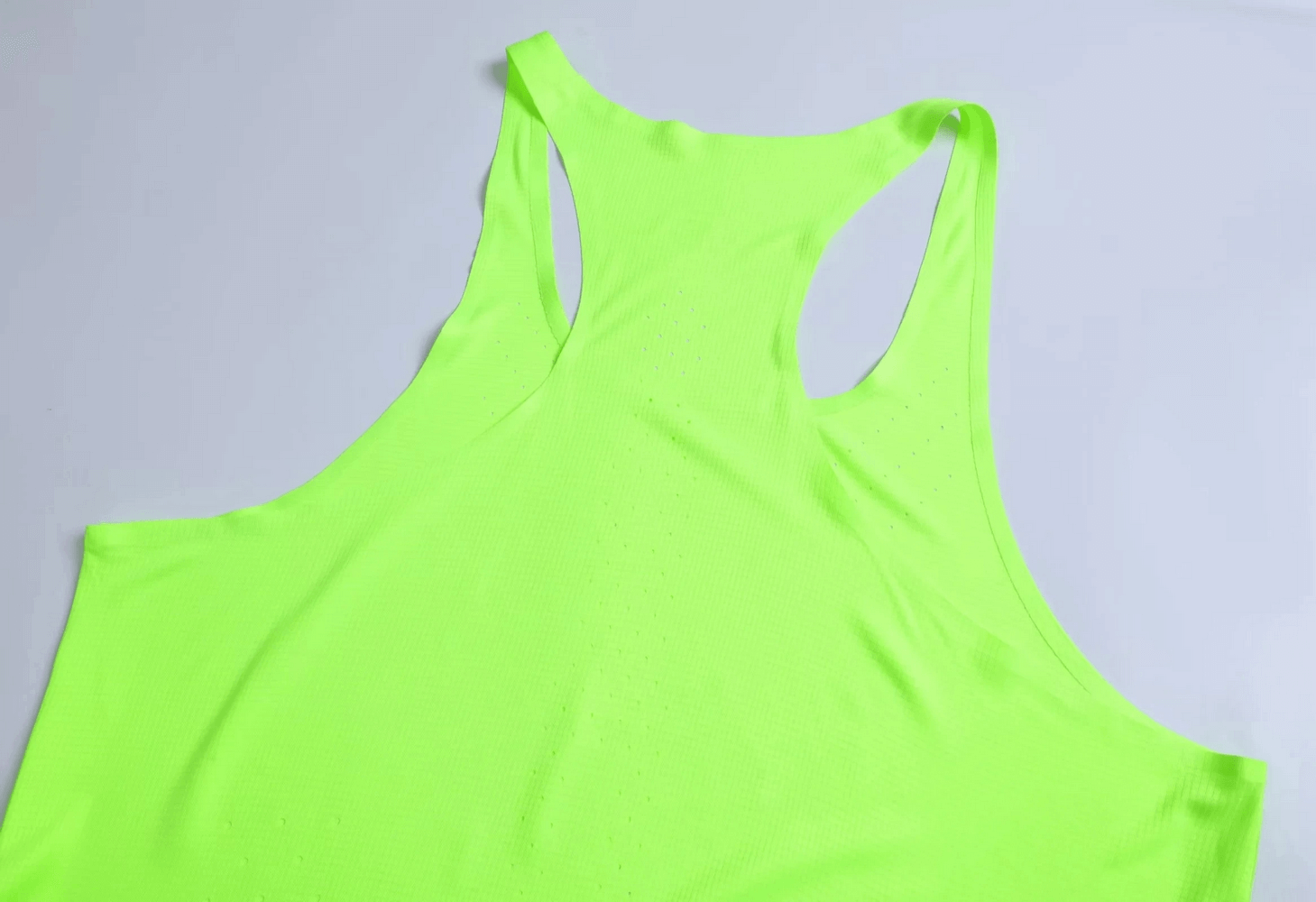 Vibrant color breathable men’s tank top with perforated design for optimal airflow and athletic fit. Perfect for intense workouts.