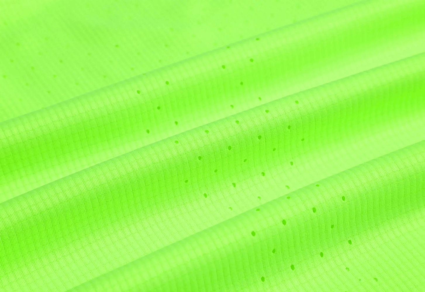Close-up of breathable perforated athletic fabric in vibrant green, perfect for workout wear.