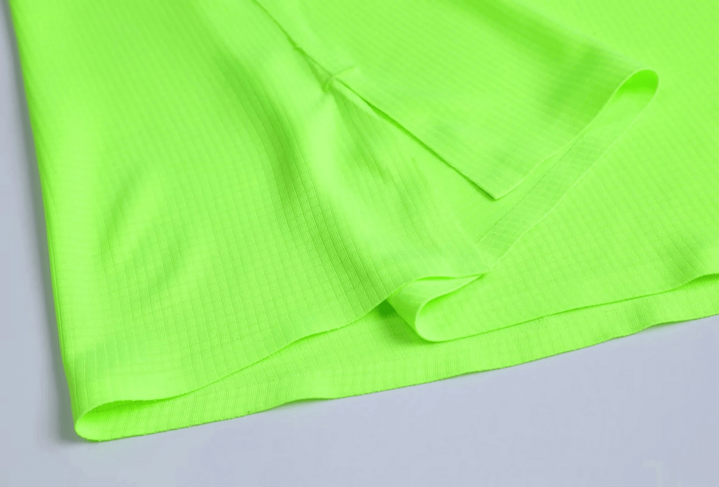 Close-up of neon green breathable men’s tank top with athletic fit, highlighting its vibrant color and perforated design.