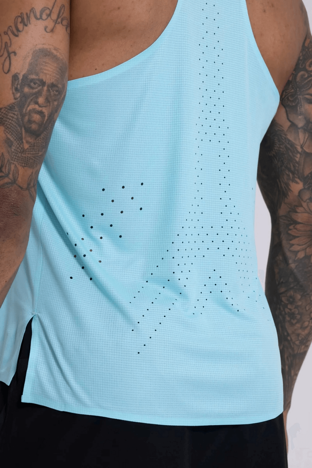 Athlete wearing breathable blue tank top with perforated design for optimal airflow in workouts, showcasing athletic fit.