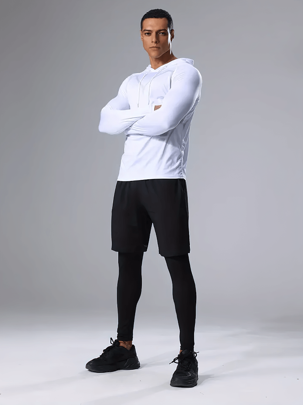 Model wearing breathable men's 3-piece workout set SF2625, featuring white hoodie, black shorts, and tights for optimal performance.