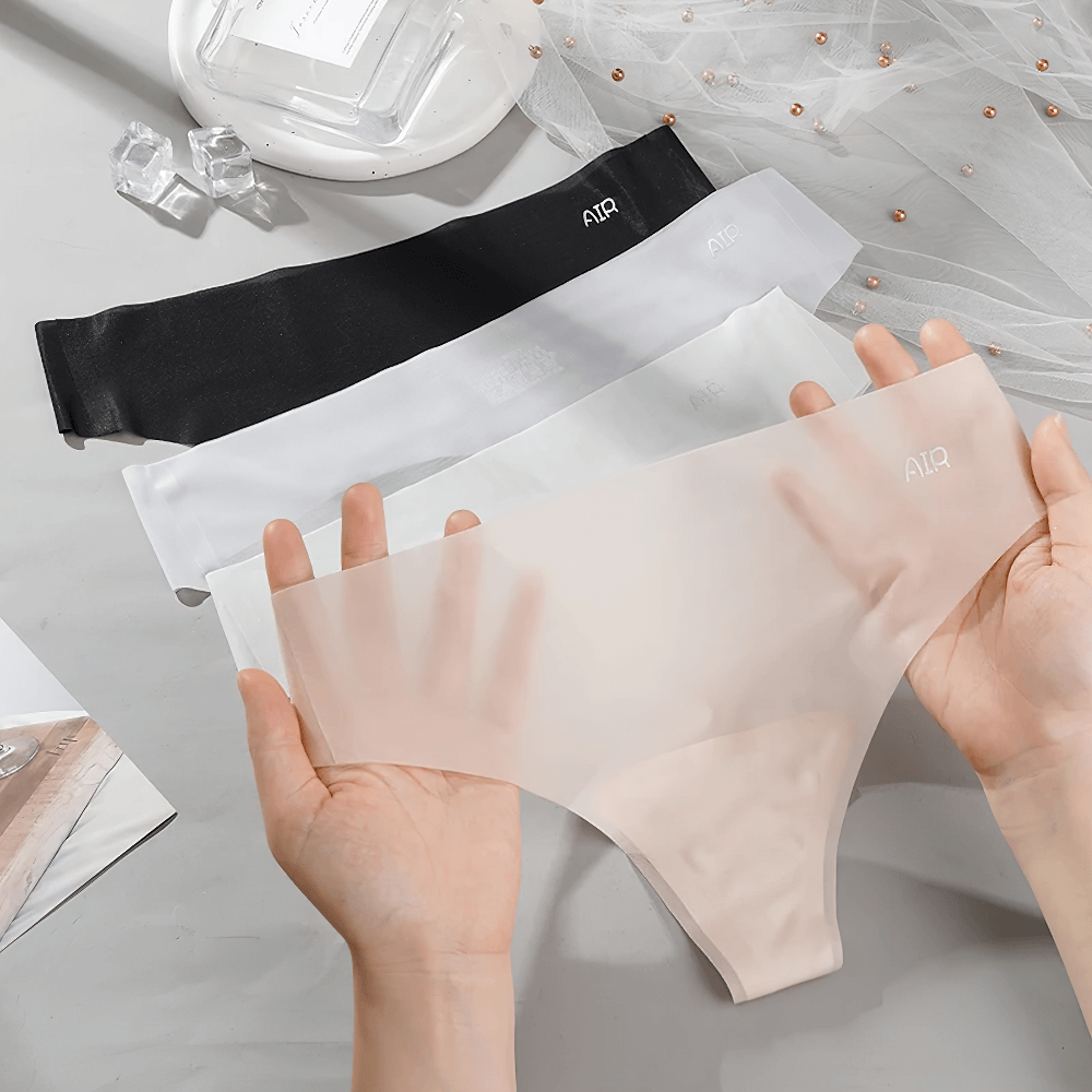 Hands holding a beige seamless thong with black and white options displayed, showcasing breathable and lightweight fabric.