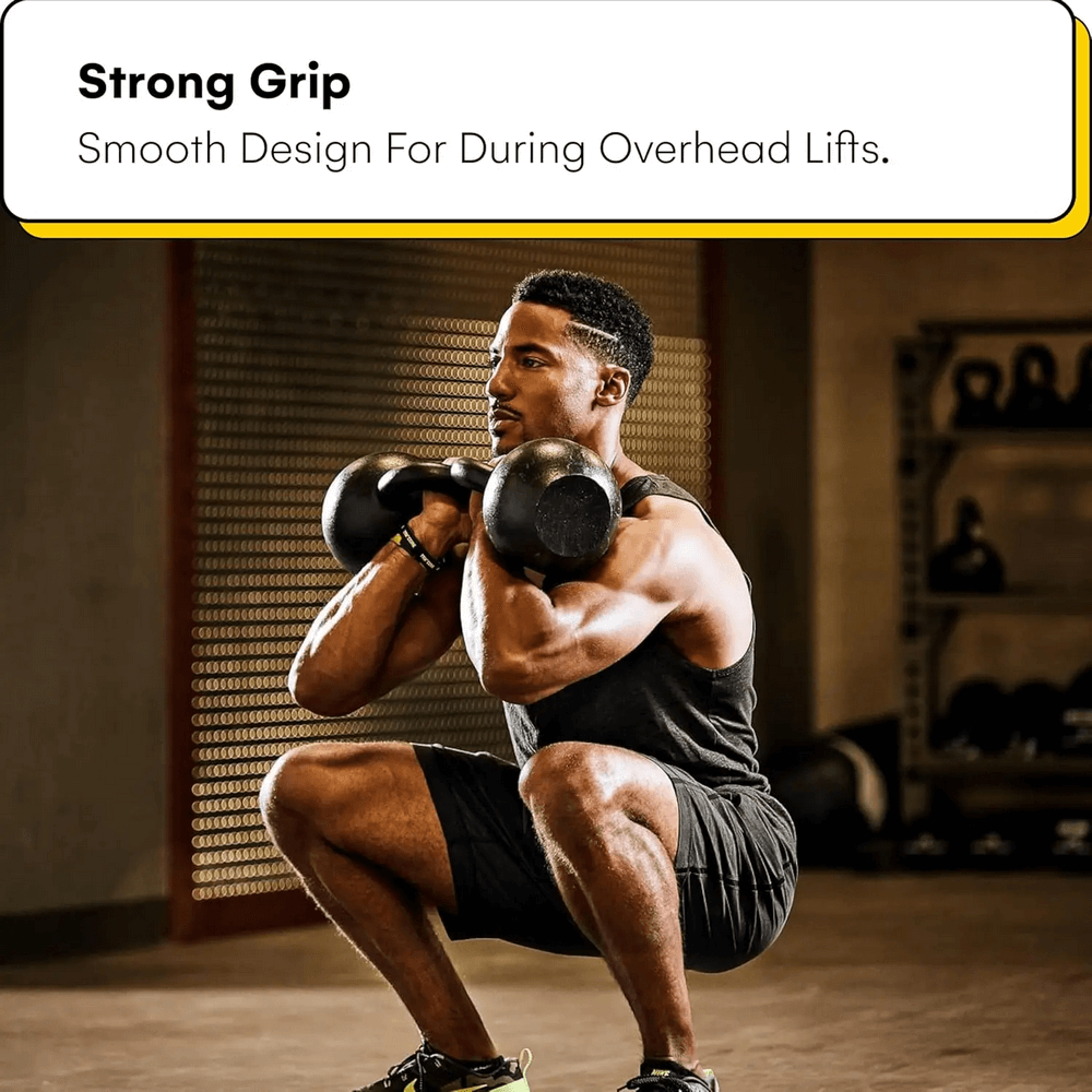 Person squatting with cast iron kettlebells during a workout, showing strong grip and smooth design for overhead lifts in a gym setting.