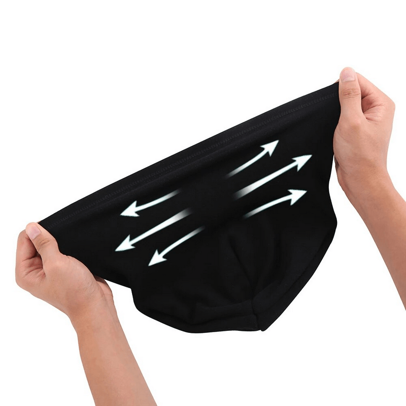 Hands stretching a black beanie with white arrows showing elasticity and flexibility of the fabric, highlighting durability and comfort.