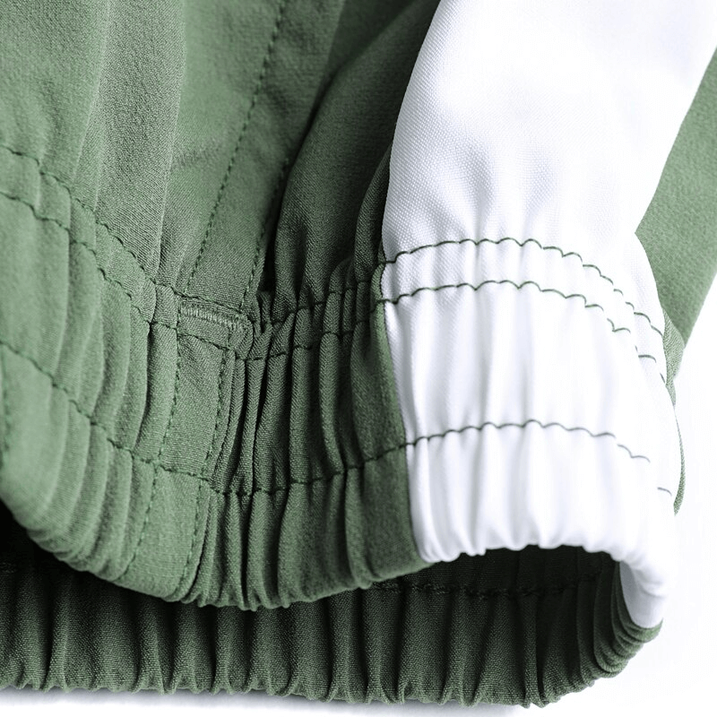 Close-up of green sports pants with elastic waistband and white accents, emphasizing breathability and comfort for active men.