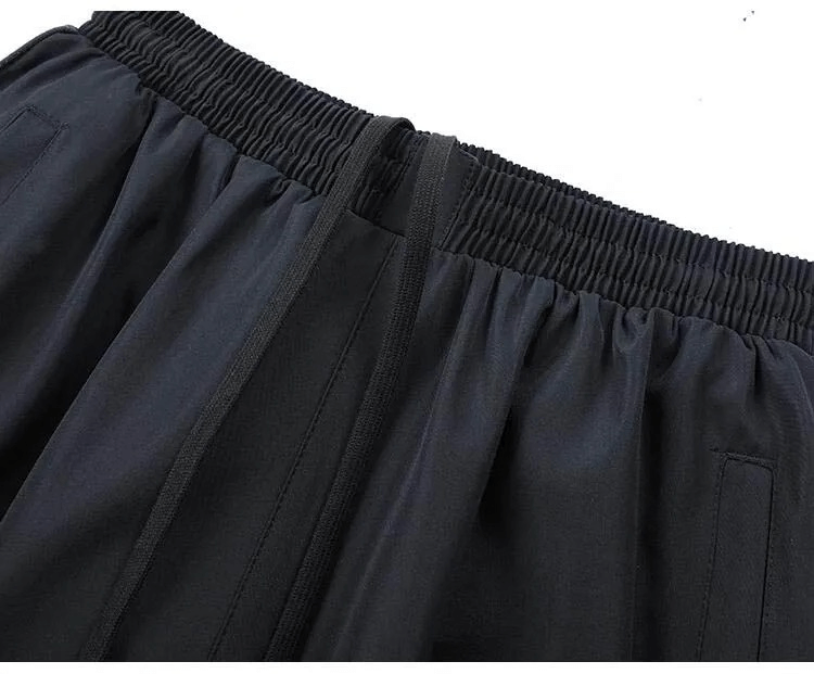 Close-up of black elastic waist pants from men's spring sportswear set, showcasing comfortable fit and durable material.