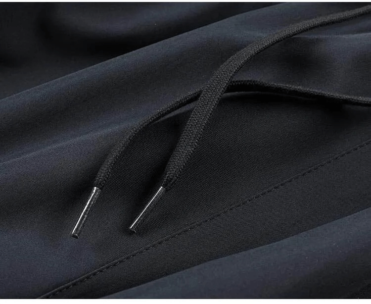 Close-up of black drawstring on men's polyester casual track suit pants.