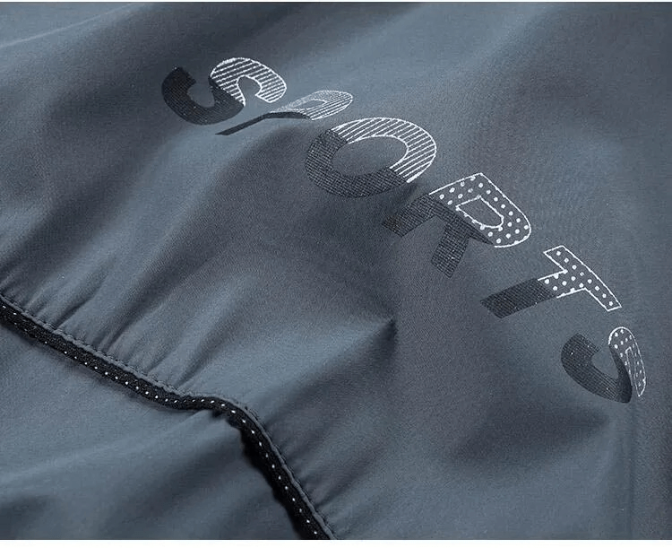 Close-up of gray polyester sports jacket with 'SPORTS' text and zippered detail, part of the men's SF2034 tracksuit.