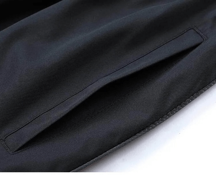 Close-up of zippered pocket on men's black track suit jacket, showcasing durable polyester fabric and sleek design for sportswear.