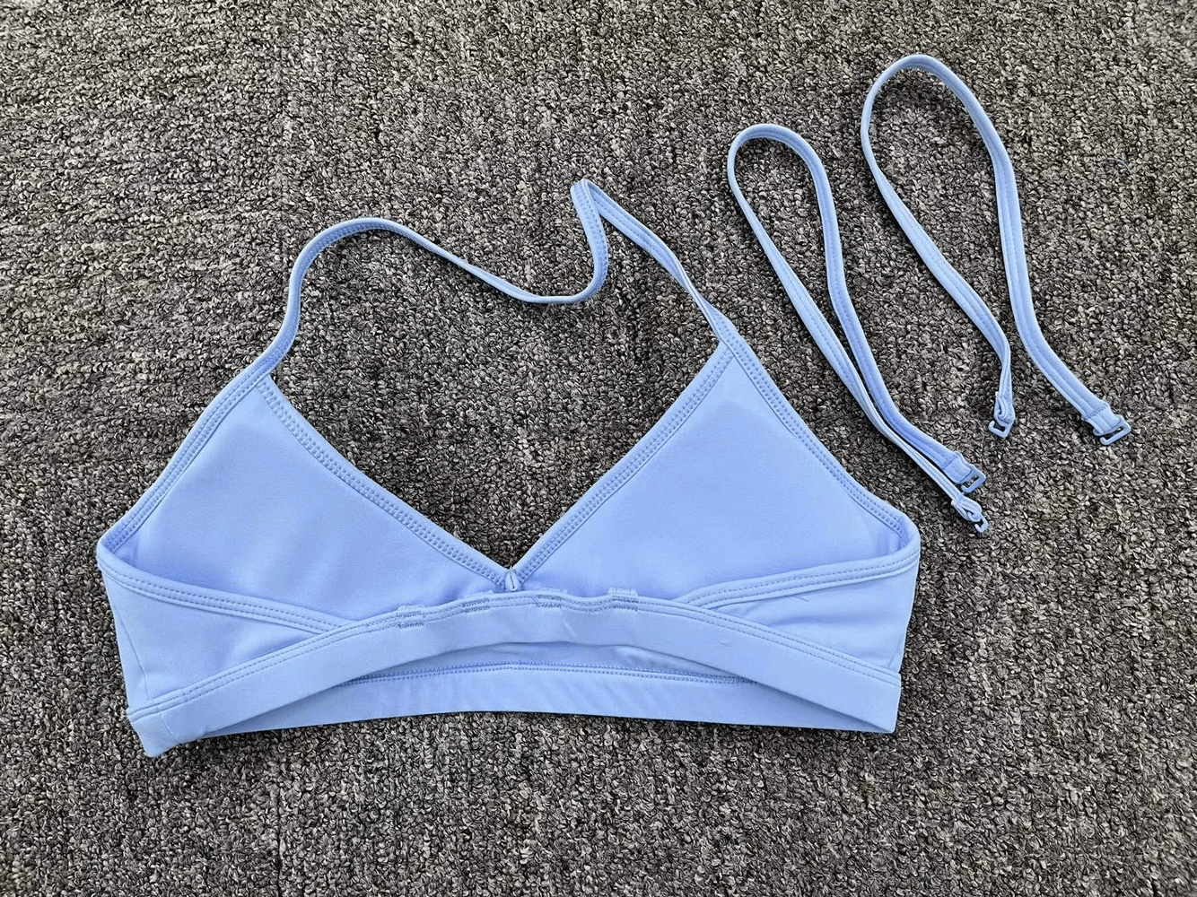 Light blue multi-strap sports bra for active wear, featuring a chic strappy back design. Ideal for yoga or fitness activities.