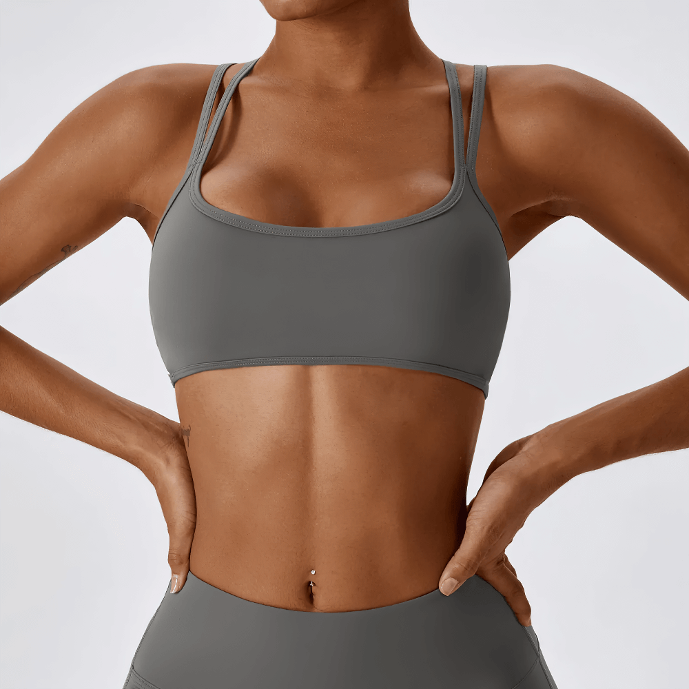 Woman wearing chic blue sports bra with cross-back design, ideal for active wear and providing maximum support for workouts.