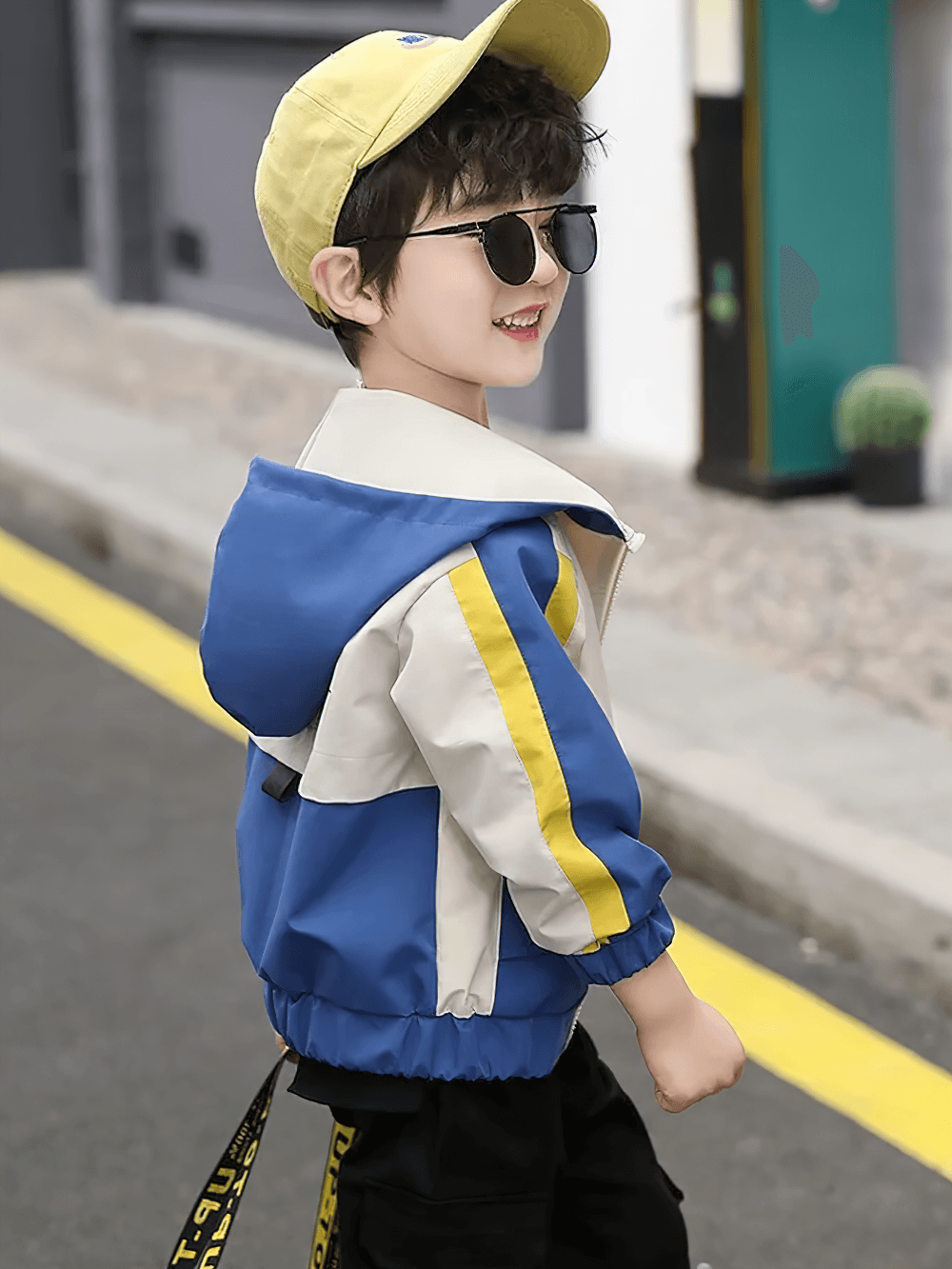 Boy wearing Color Block Zip Windbreaker Hooded Jacket - SF3547 in blue and yellow, stylish and functional for outdoor activities.