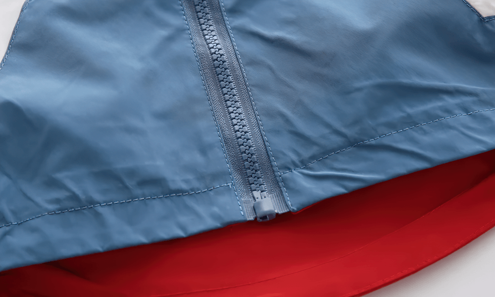 Close-up of the Colorblock Hooded Windbreaker Jacket for Kids - SF3603 zipper and hood design in blue and red.
