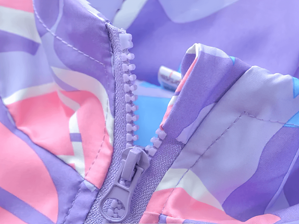 Close-up of Colorful Windbreaker Jacket with Fleece Lining - SF3579 zipper detail showing vibrant pink, blue, and purple geometric design.