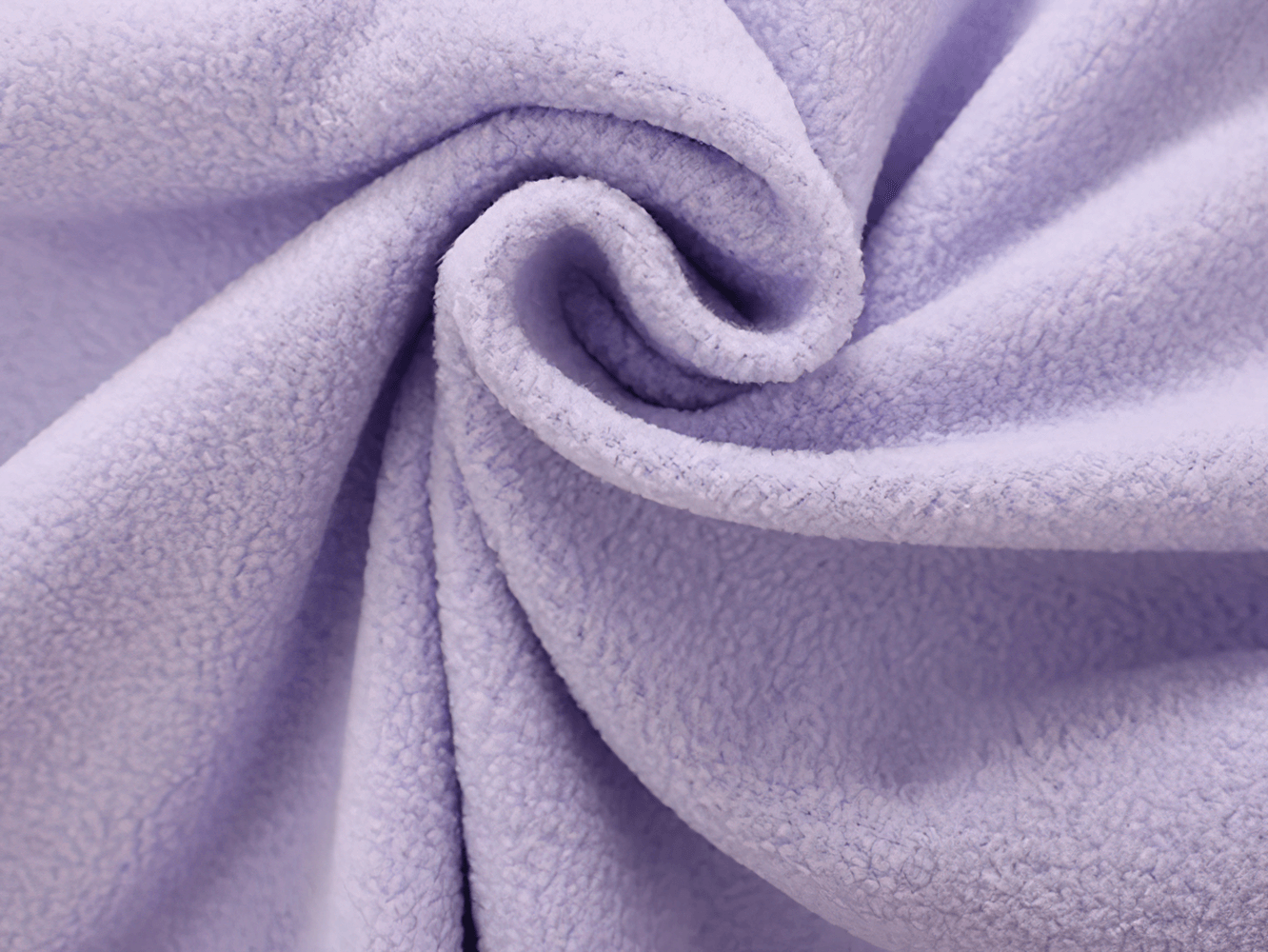 Close-up of soft, swirling lavender fleece fabric texture in a cozy spiral design.