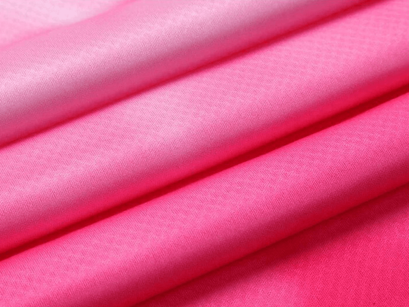 Vibrant pink polyester fabric showcasing breathable texture for gym wear