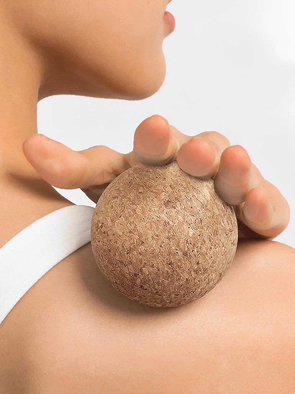 Natural cork massage ball on shoulder for deep tissue and muscle relief, perfect for yoga and fitness routines.