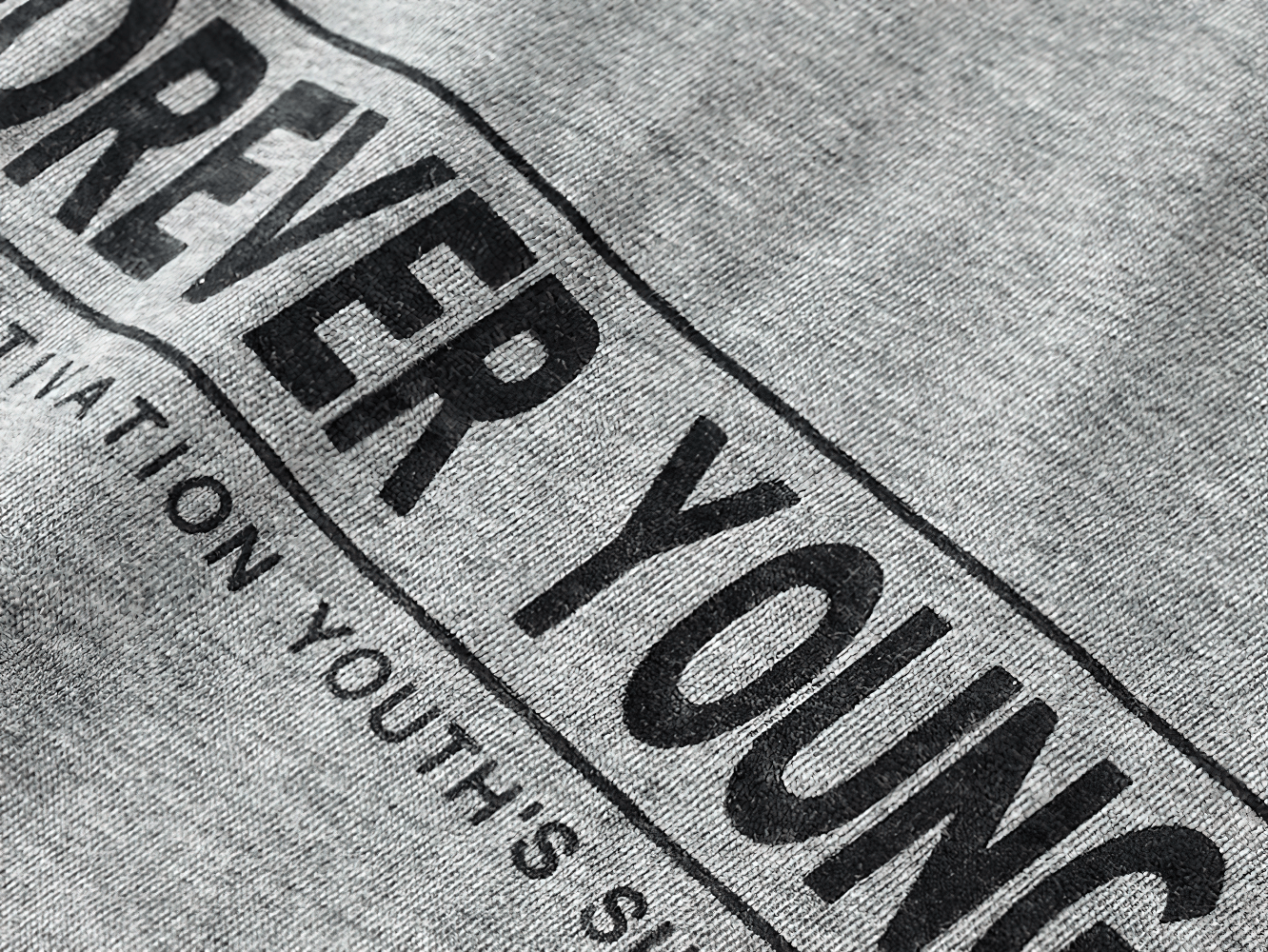 Close-up of "Forever Young" motivational print on grey cotton boys' long-sleeve top, showcasing youthful energy and style.