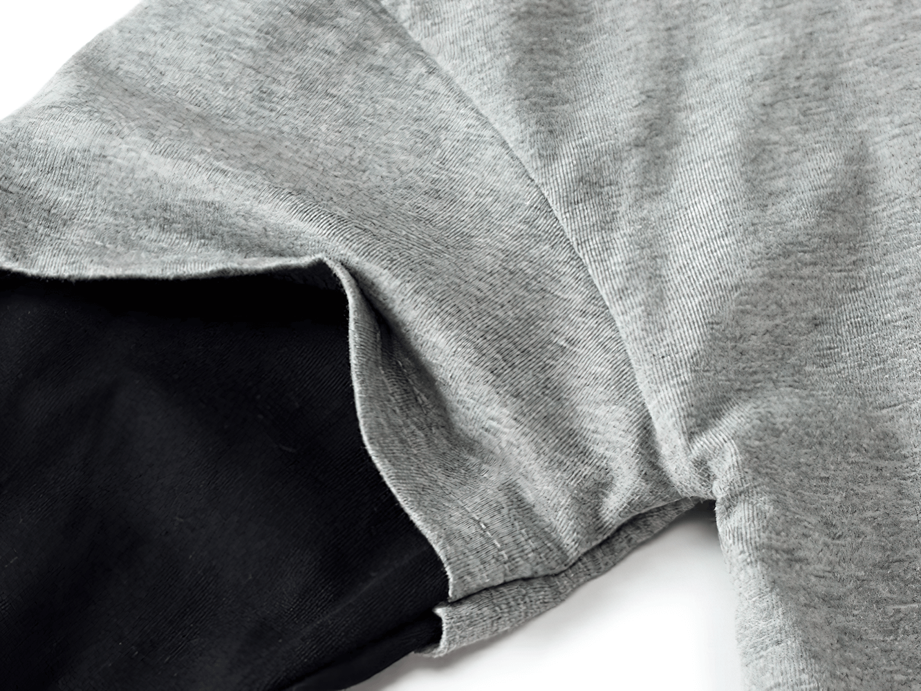 Close-up of grey and black long-sleeved cotton top with "Forever Young" motif, showcasing sporty contrasting sleeve details.