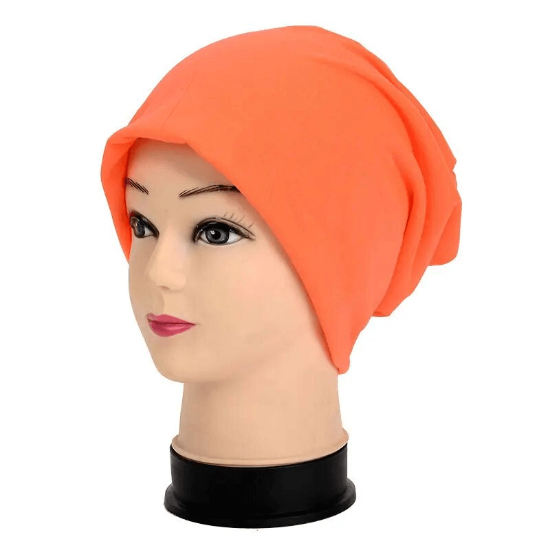 Orange cotton soft lightweight slouchy beanie for running displayed on a mannequin head, perfect for casual outdoor activities.