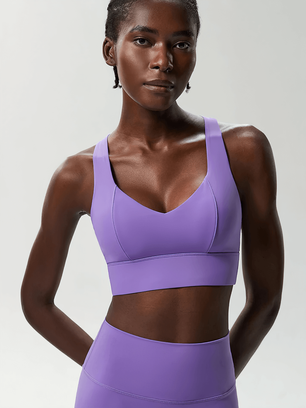 Model wearing Crisscross Back Sports Bra with Removable Pads - SF4040, V-neck racerback in purple, ideal for yoga and workouts.