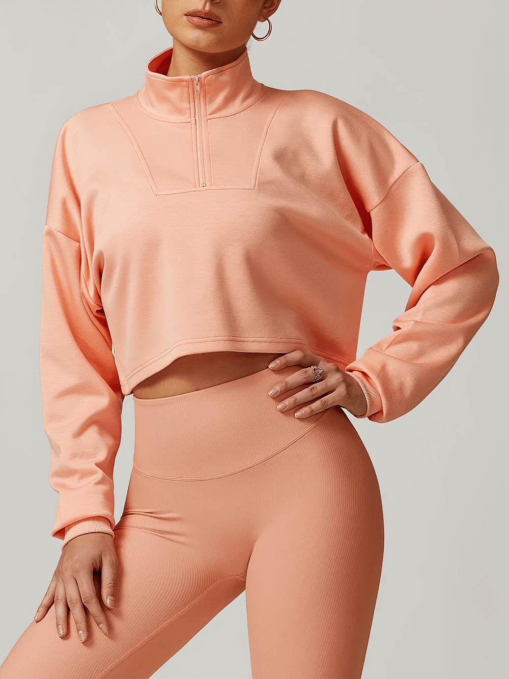 Trendy pink cropped zip-up sweatshirt for women, perfect for workouts and lounging, featuring a relaxed fit with drop shoulders.