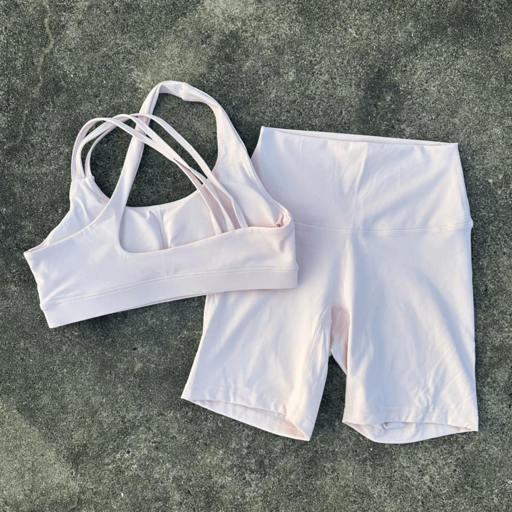 Alt Tag: Cross Back Yoga Bra and High Waist Gym Shorts Set - SF4355 white cross-back sports bra with high-waist shorts on concrete