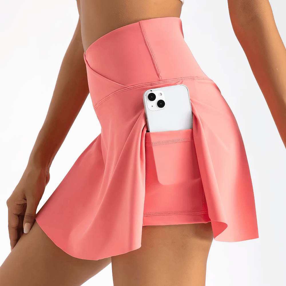 Alt Tag: Crossover High Waist Golf Skirt with Pocket - SF4439, pink pleated tennis skort with inner shorts and side pocket holding phone