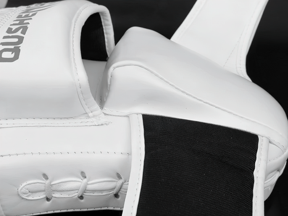 Curved PU leather focus pads with dense padding for boxing and MMA training, featuring reinforced stitching and hand-shaped mold.