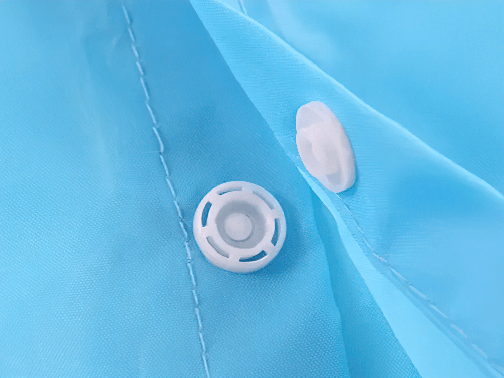 Close-up of snap buttons on Cute Animal Hooded Waterproof Raincoat with Pockets - SF3616, showcasing vibrant blue waterproof fabric.