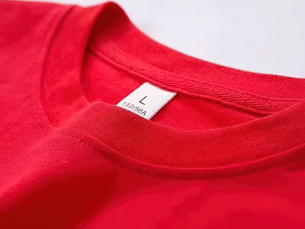 Close-up of a vibrant red T-shirt collar with a size L label visible, showcasing its soft fabric and stitching details