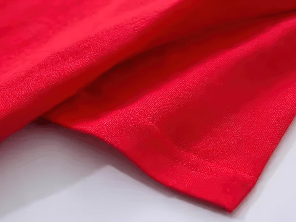 Close-up of vibrant red fabric from a kids' graphic tee, showcasing soft texture and quality material.